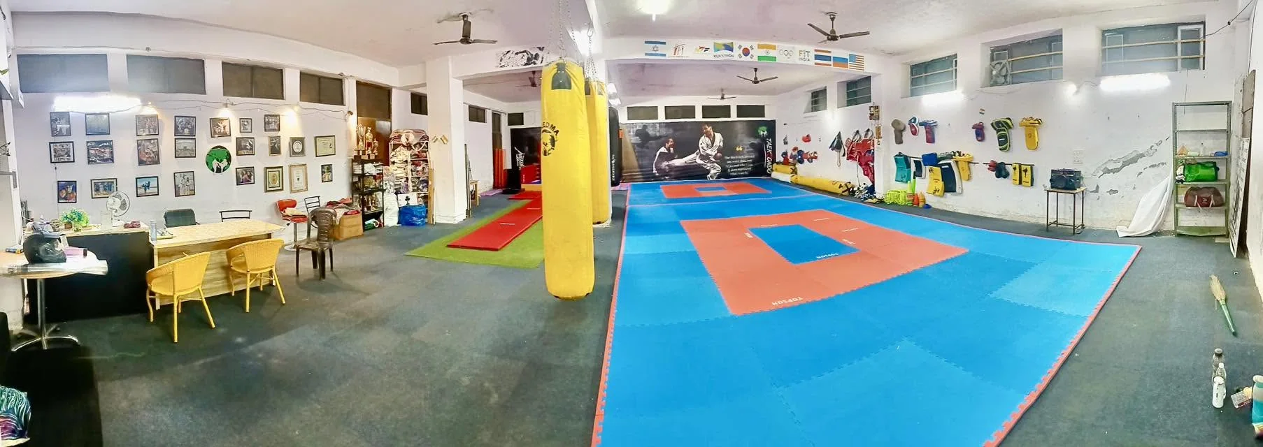 Wide view of academy training mats, punching bags and wall displays