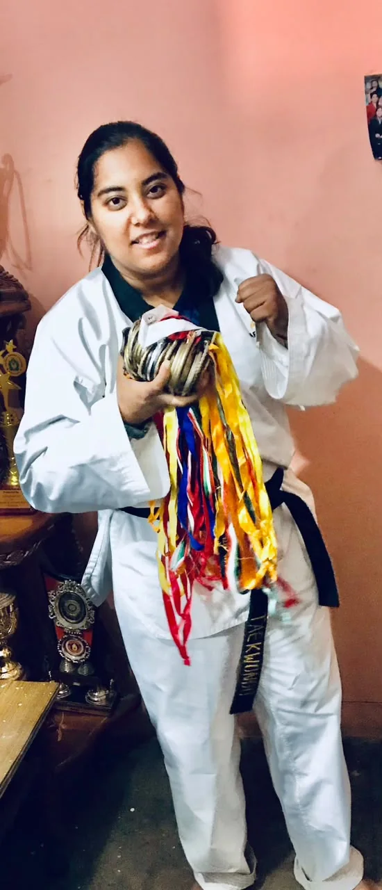 Richa Gaur in a martial arts uniform holding medals